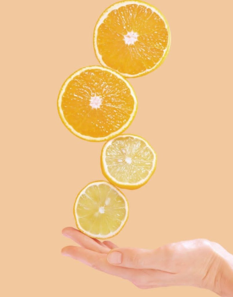 persona sosteniendo pedazos de naranja en sus manos