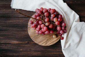 tabla con uvas maduras en una mesa de madera