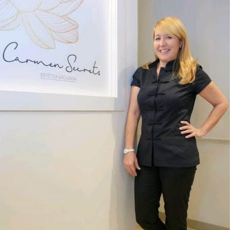 Cosmetóloga en Barcelona en la clínica Carmen Secrets, retrato profesional junto al logotipo